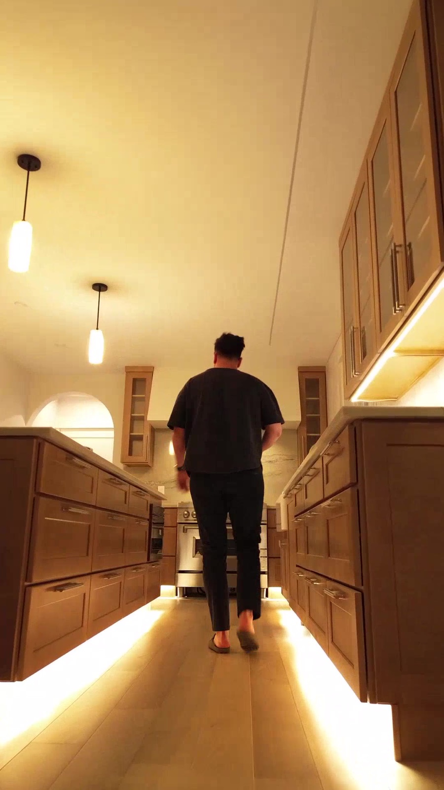 Figure walking through Casa TRES kitchen at night with under-cabinet glow