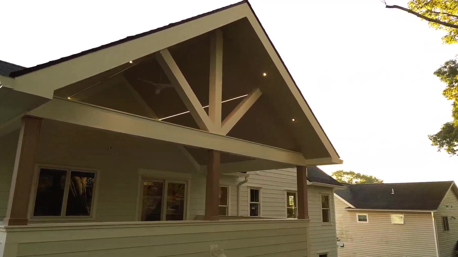 Casa TRES covered porch under timber gable in warm daylight