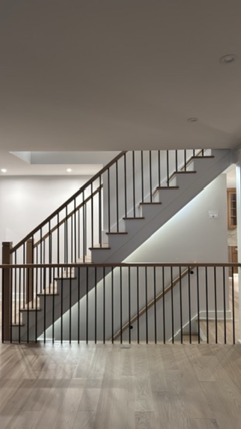 Open staircase with black metal balusters and wood treads at Casa TRES