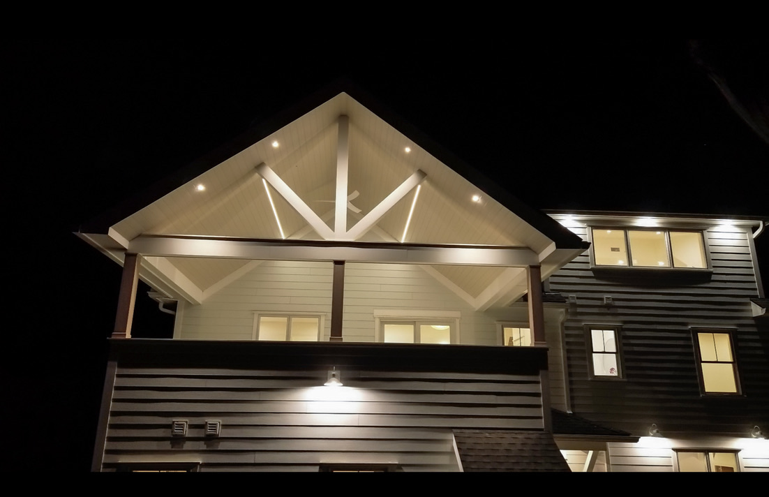 Three-quarter view of Casa UNO covered porch at dusk in black and white.