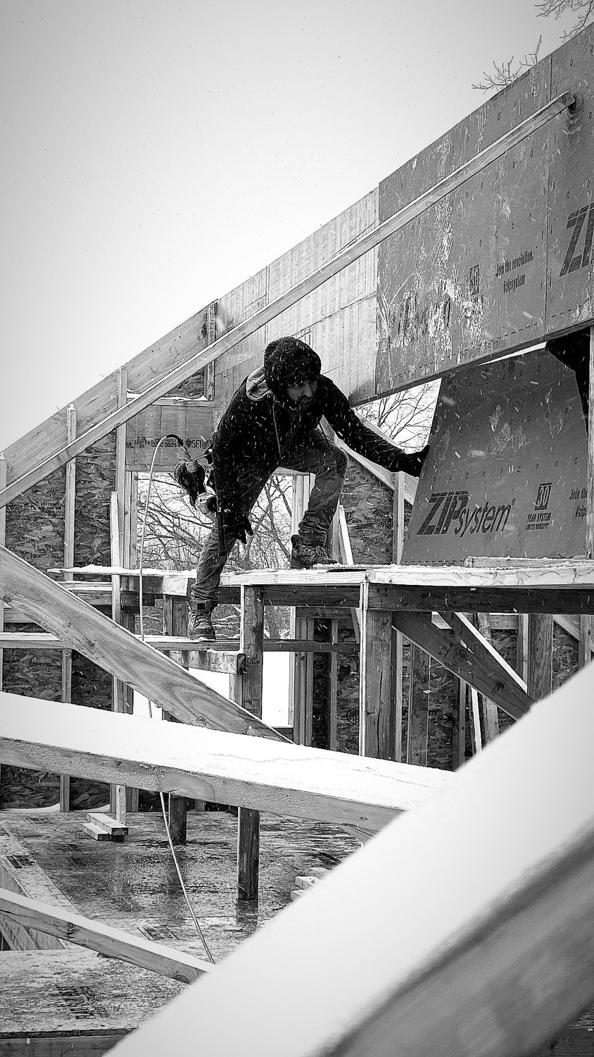 A builder at work on a More Life home, black and white.