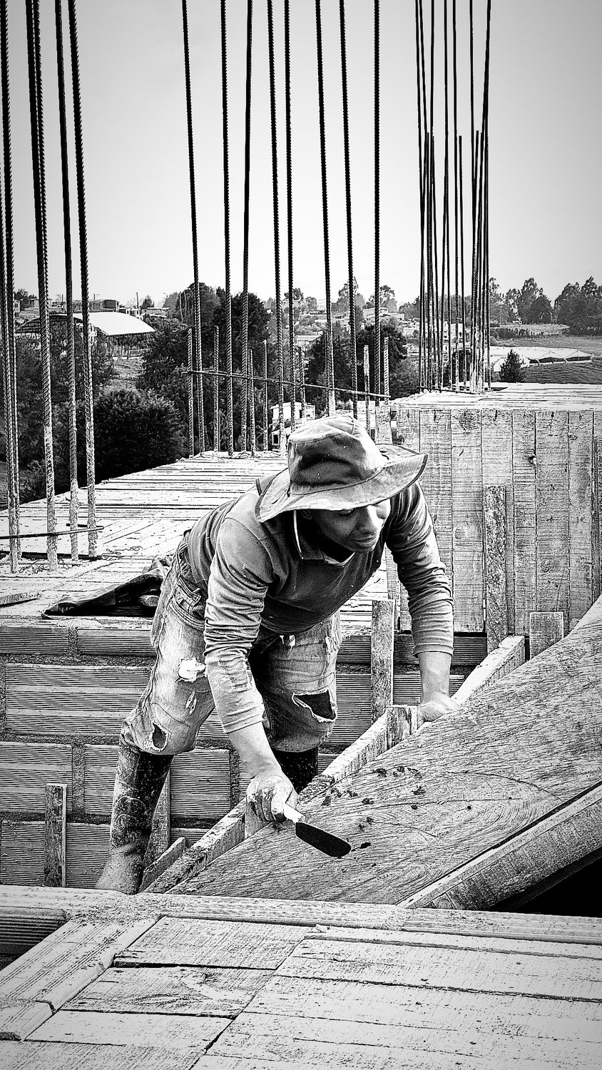 A builder at work on a More Life home, black and white.