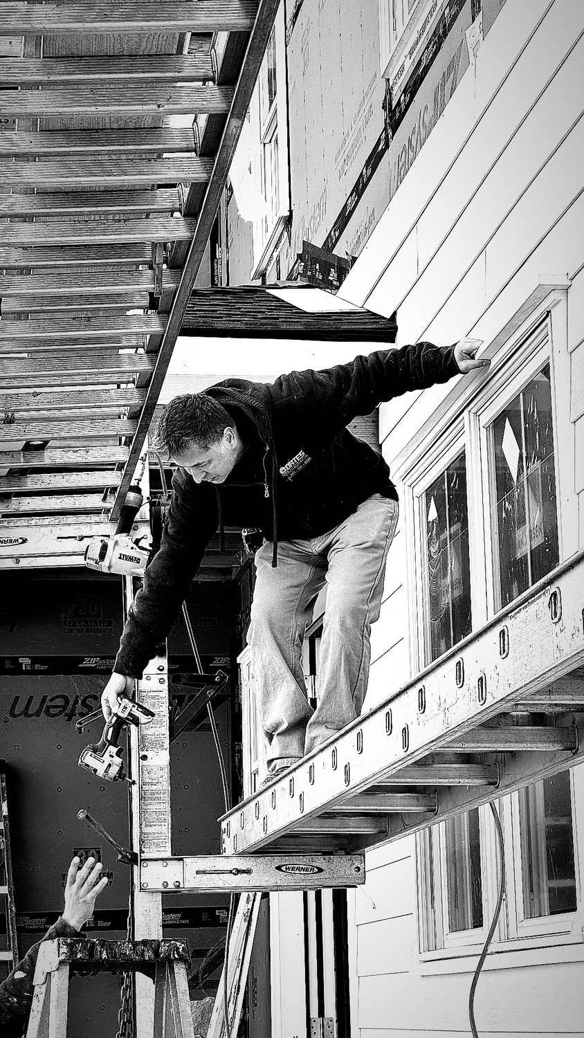 A builder at work on a More Life home, black and white.