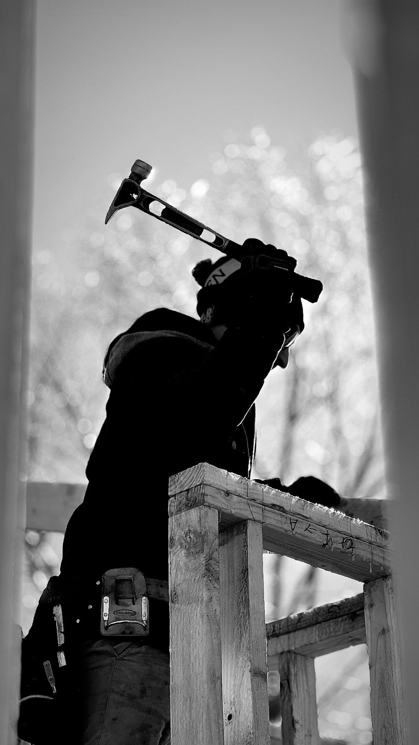 A builder at work on a More Life home, black and white.