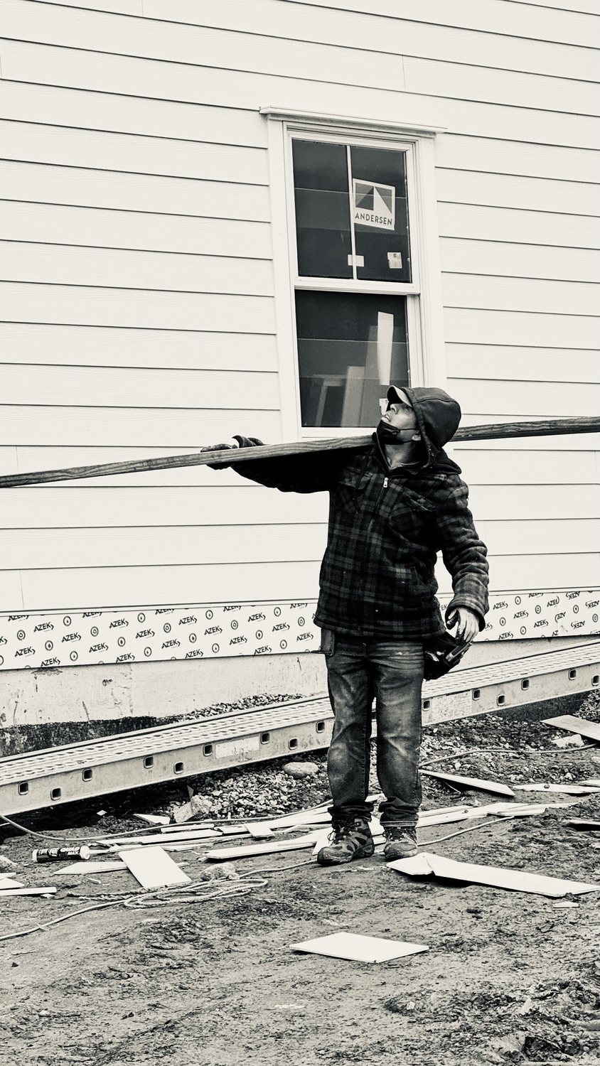 A builder at work on a More Life home, black and white.